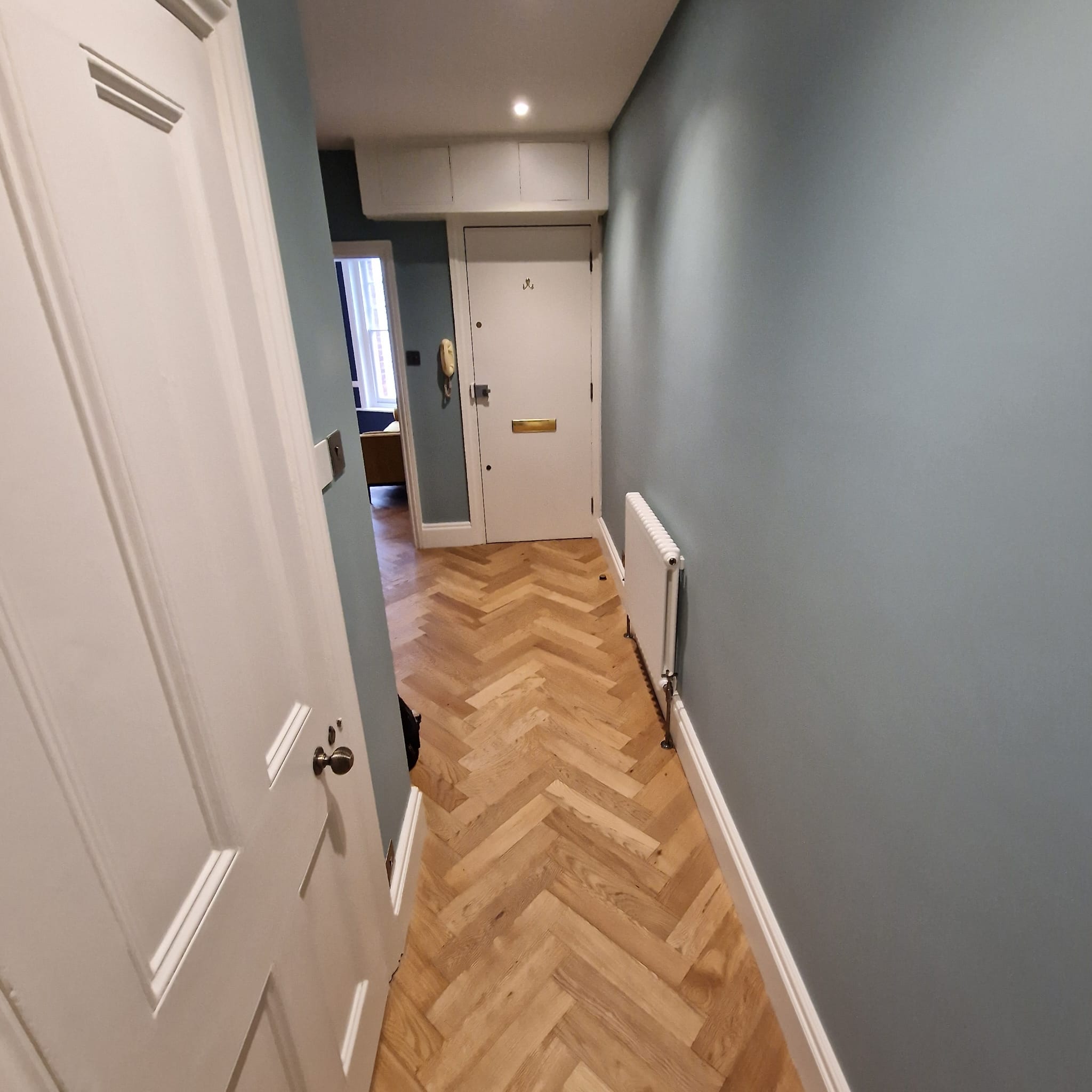 Front entrance hallway with parquet flooring and slate-blue walls